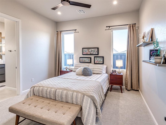 carpeted bedroom with ensuite bath and ceiling fan