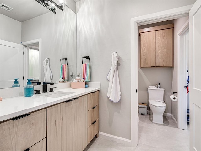 bathroom featuring tile patterned floors, vanity, and toilet