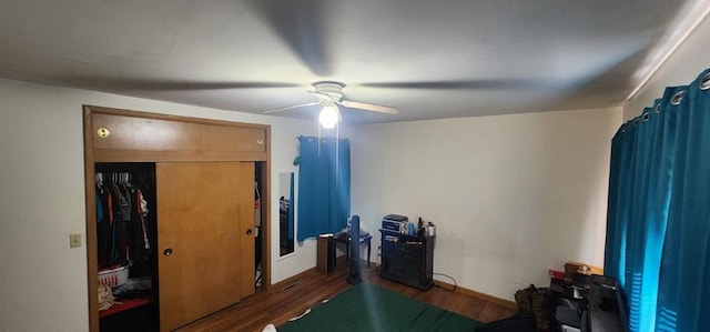 bedroom with ceiling fan, dark hardwood / wood-style flooring, and a closet