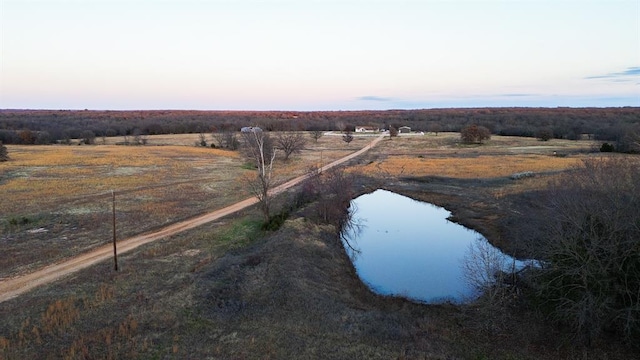 aerial view at dusk with a rural view and a water view