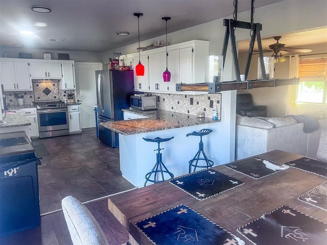 kitchen featuring white cabinets, stainless steel appliances, and kitchen peninsula