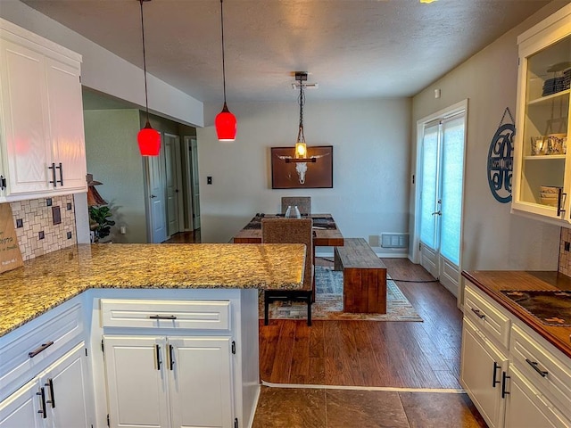 kitchen with white cabinetry, backsplash, pendant lighting, and kitchen peninsula