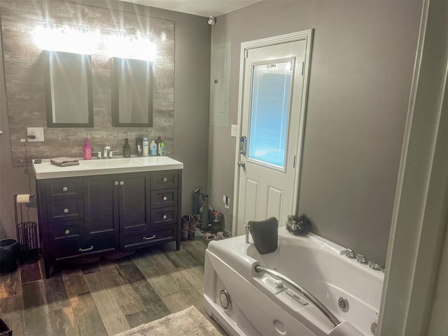 bathroom with hardwood / wood-style floors, a tub, and vanity