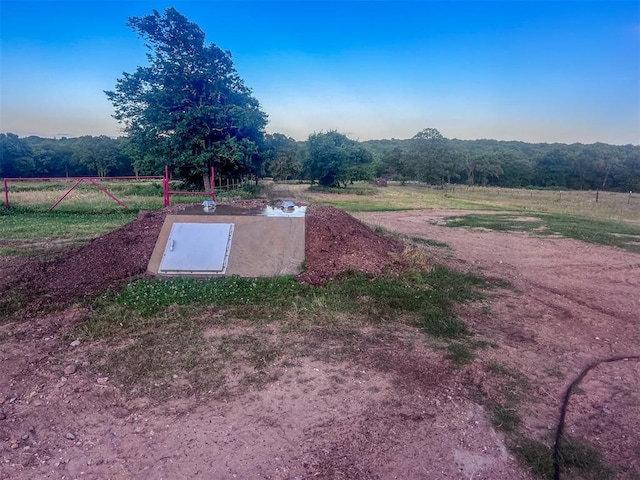 entry to storm shelter with a rural view