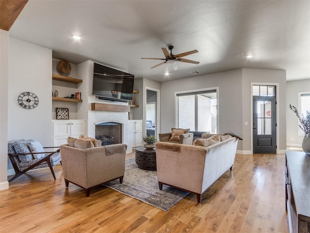 living room featuring light hardwood / wood-style floors and ceiling fan