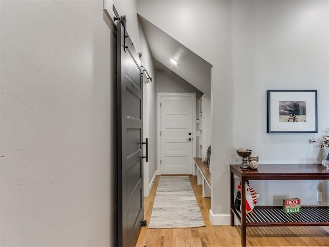 hallway with wood-type flooring and a barn door