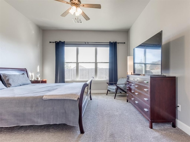 bedroom with ceiling fan, light carpet, and multiple windows