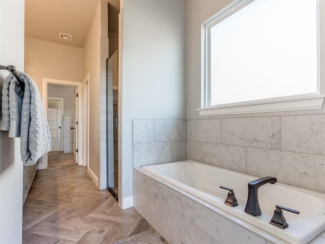 bathroom featuring parquet flooring and separate shower and tub