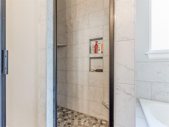 bathroom featuring an enclosed shower and tile walls