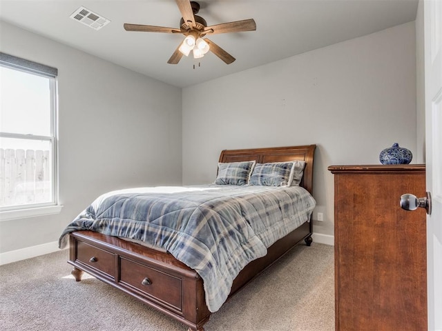 bedroom featuring ceiling fan, light carpet, and multiple windows