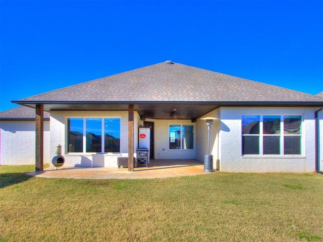 rear view of house featuring ceiling fan, a yard, and a patio