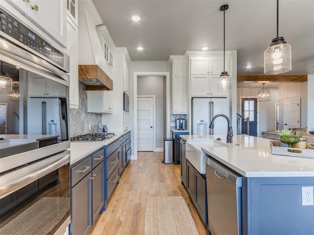 kitchen featuring pendant lighting, white cabinetry, stainless steel appliances, and blue cabinets