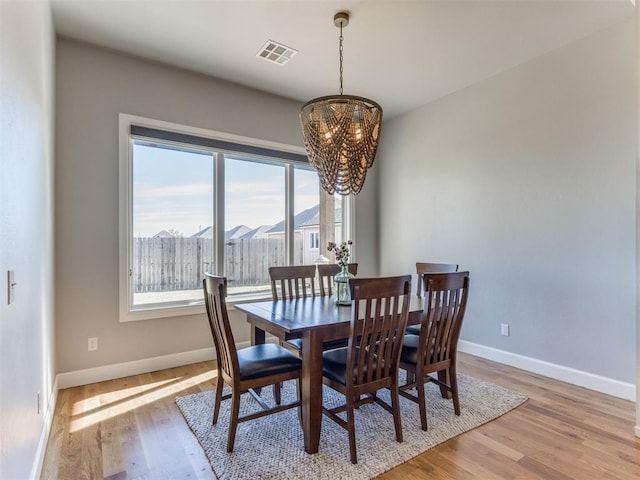 dining space featuring a notable chandelier and light hardwood / wood-style floors