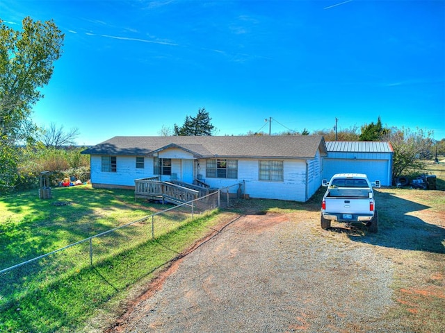 single story home featuring a garage, an outdoor structure, and a front lawn