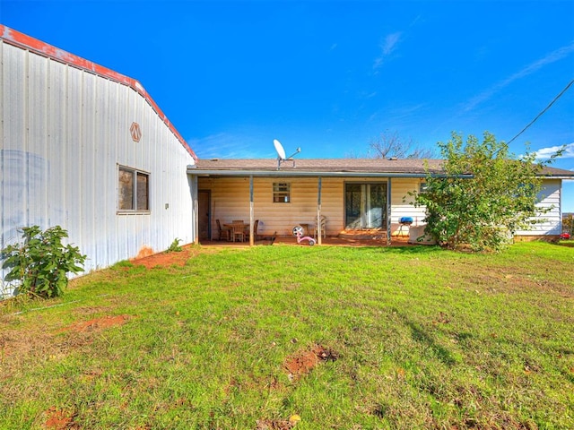 rear view of property featuring a yard