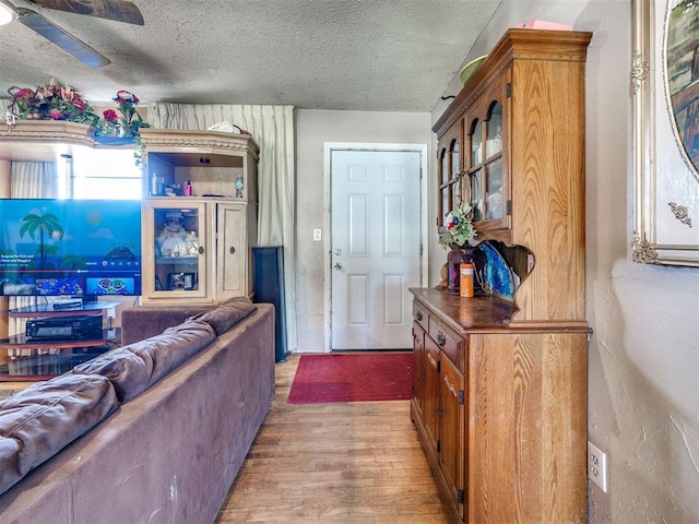 living room featuring a textured ceiling, hardwood / wood-style flooring, and ceiling fan