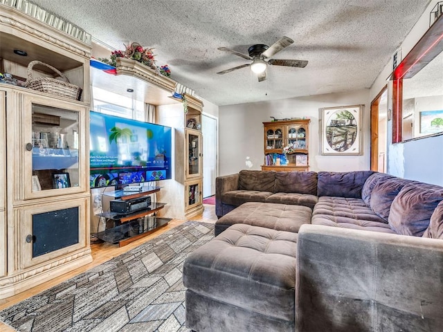 living room featuring a textured ceiling, hardwood / wood-style flooring, and ceiling fan