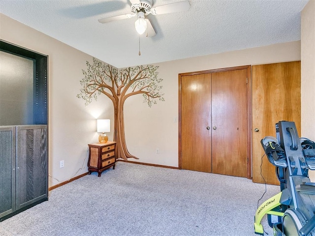 bedroom featuring a textured ceiling, a closet, ceiling fan, and light colored carpet