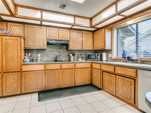 kitchen with decorative backsplash, sink, light tile patterned floors, and stainless steel appliances