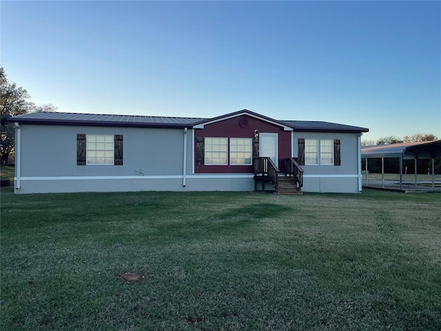 manufactured / mobile home with a front lawn and a carport