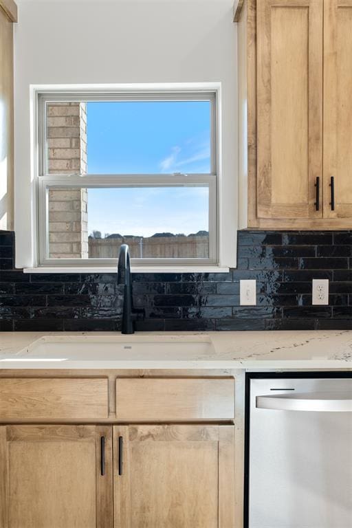 kitchen featuring backsplash, stainless steel dishwasher, and light brown cabinetry