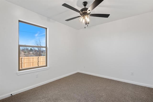 empty room with carpet, a ceiling fan, and baseboards