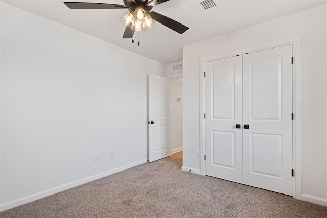 unfurnished bedroom featuring ceiling fan, light carpet, and a closet