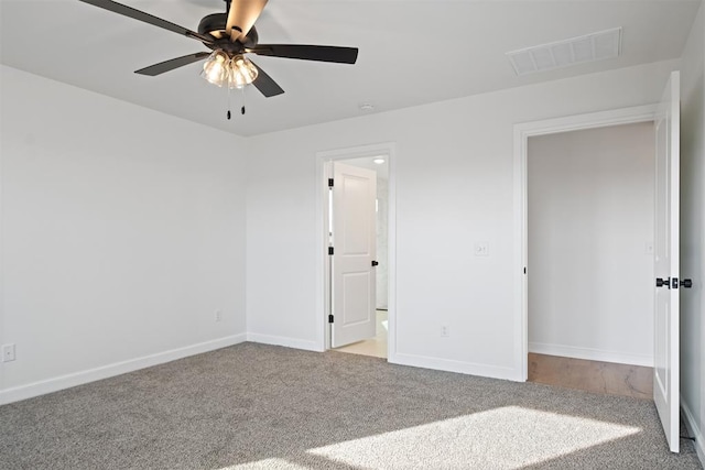 unfurnished bedroom featuring ensuite bath, ceiling fan, and light carpet