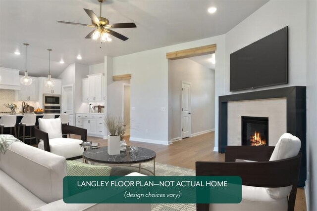 living area with baseboards, a lit fireplace, recessed lighting, light wood-style flooring, and a ceiling fan