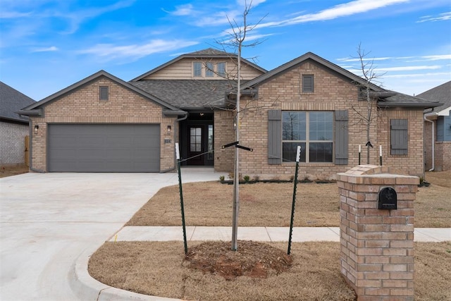 view of front of home with brick siding, an attached garage, concrete driveway, and roof with shingles