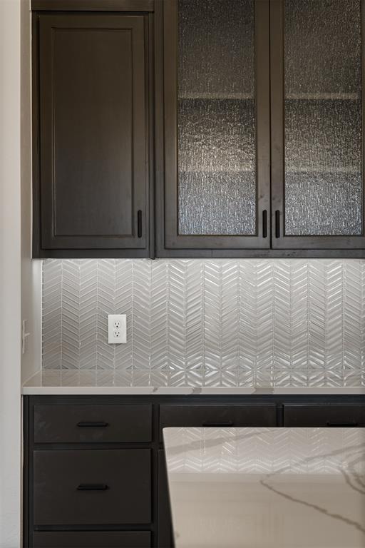 804 Argos Rd, Yukon, OK 73099 - kitchen with decorative backsplash, dark brown cabinets, and glass insert cabinets