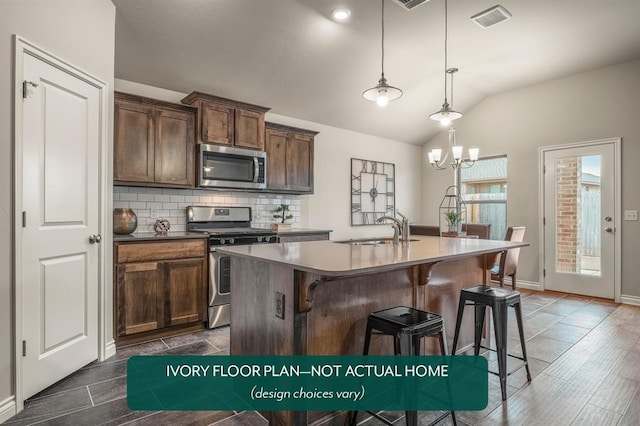 kitchen featuring pendant lighting, a center island with sink, sink, dark hardwood / wood-style floors, and appliances with stainless steel finishes