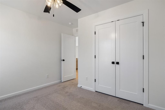 unfurnished bedroom featuring a closet, ceiling fan, and light colored carpet