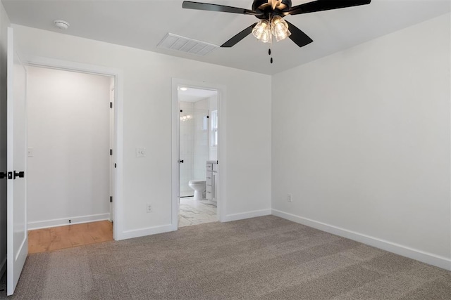 unfurnished bedroom with light colored carpet, connected bathroom, and ceiling fan