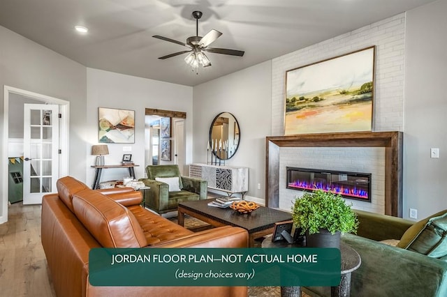 living room with ceiling fan, a fireplace, and light wood-type flooring