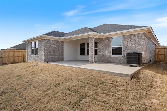 rear view of house featuring a lawn, a patio, and central air condition unit