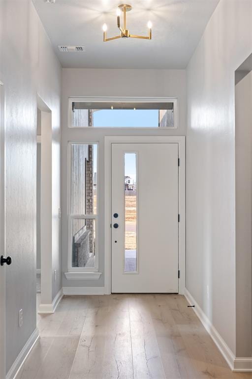 entryway with a chandelier and light wood-type flooring