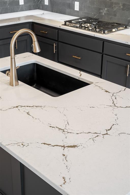 kitchen featuring backsplash, sink, and stainless steel gas cooktop