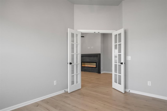 spare room with light hardwood / wood-style floors and french doors