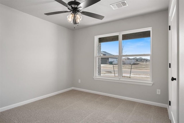 carpeted spare room featuring ceiling fan