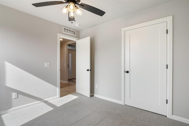 unfurnished bedroom with ceiling fan and light carpet