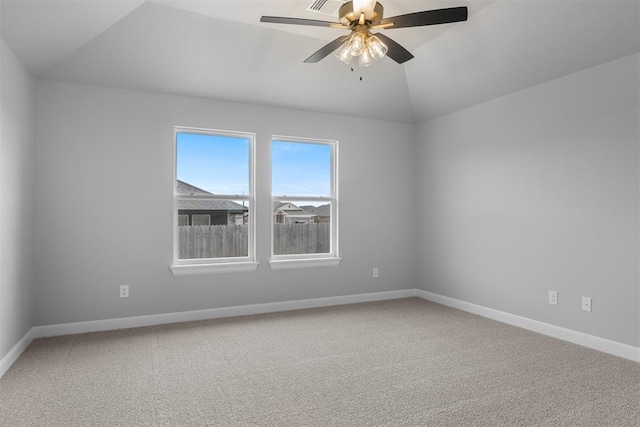 carpeted spare room featuring ceiling fan and vaulted ceiling