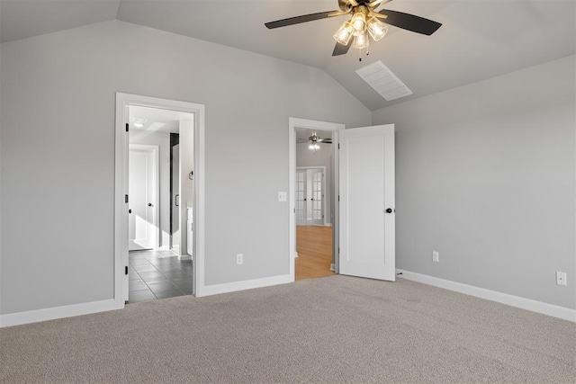 unfurnished bedroom featuring ceiling fan, lofted ceiling, light carpet, and ensuite bath