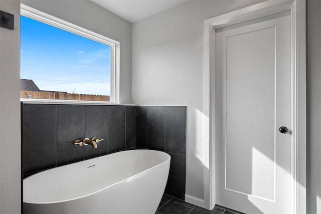 bathroom with a bath and tile patterned floors