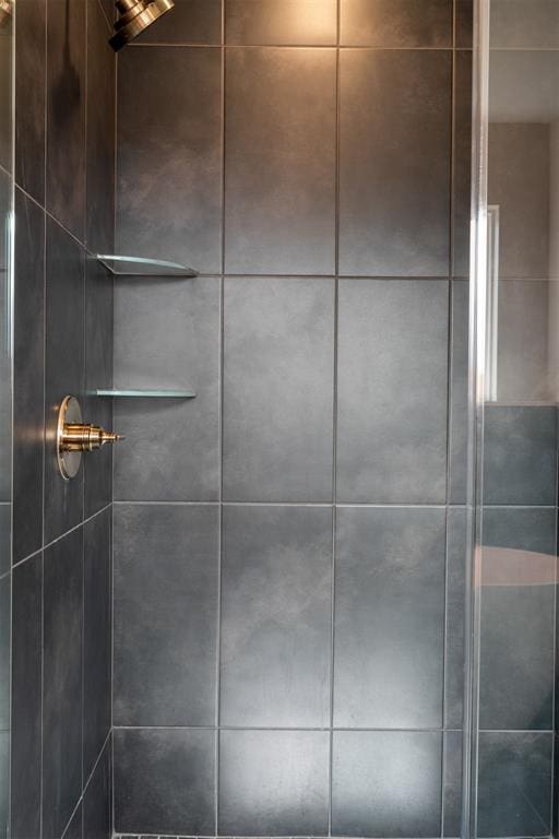 interior details featuring tiled shower