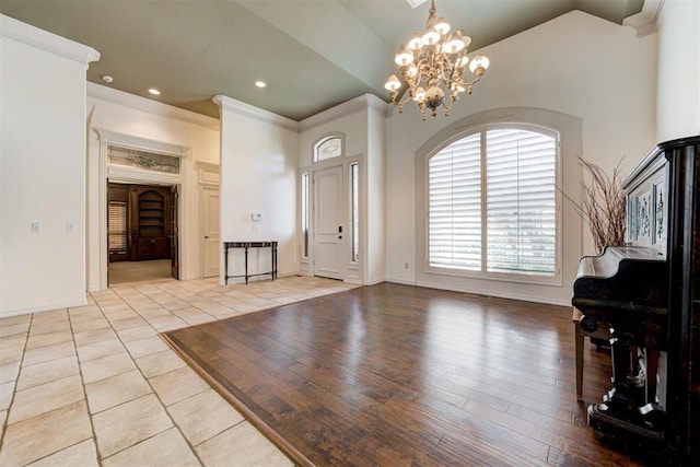 entrance foyer with light tile patterned floors, ornamental molding, and a notable chandelier