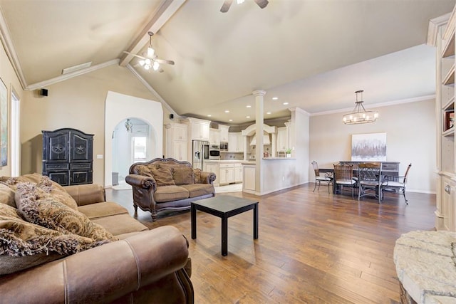 living room with beamed ceiling, ceiling fan with notable chandelier, ornamental molding, and dark wood-type flooring