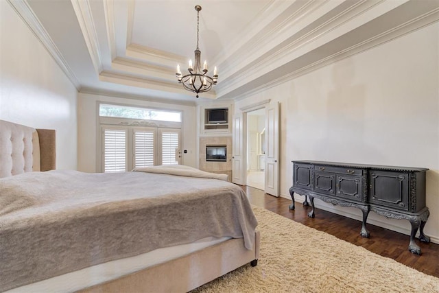 bedroom with a raised ceiling, a notable chandelier, dark hardwood / wood-style flooring, and crown molding