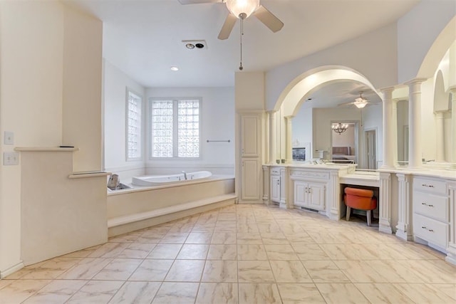 bathroom with a bathing tub, vanity, and ceiling fan with notable chandelier