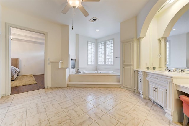 bathroom featuring ceiling fan, vanity, and a bath